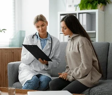 Médecin consultant un dossier auprès d'une patiente sur un canapé